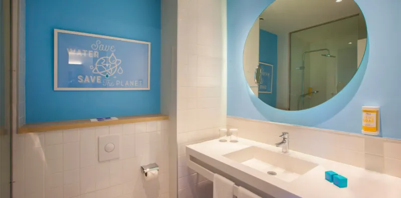 Bathroom with a washbasin and a round illuminated mirror