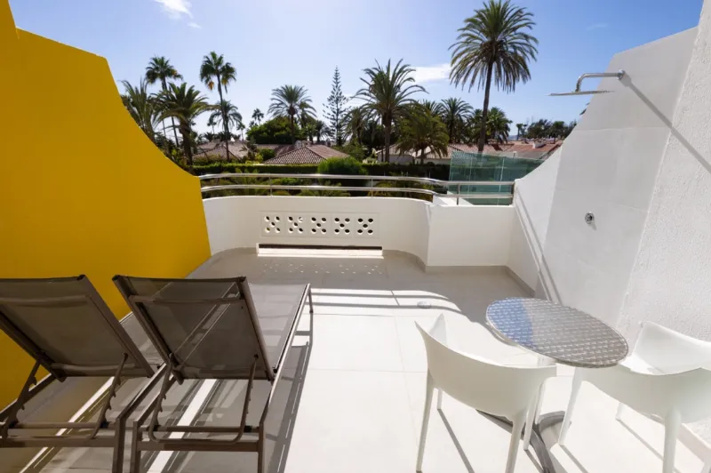 Private terrace with two sun loungers, a table and an outdoor shower